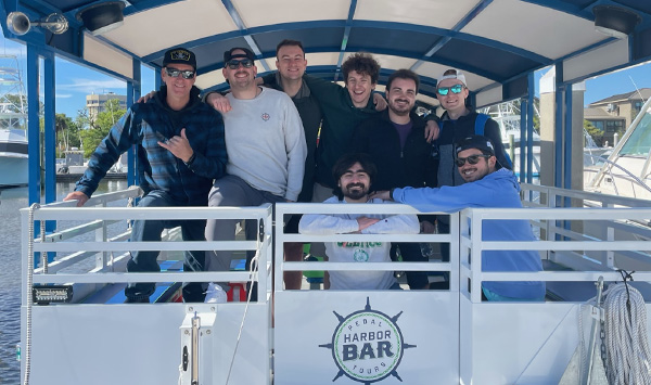 guys looking cool and posing with captain for a picture on the boat for their bachelor party