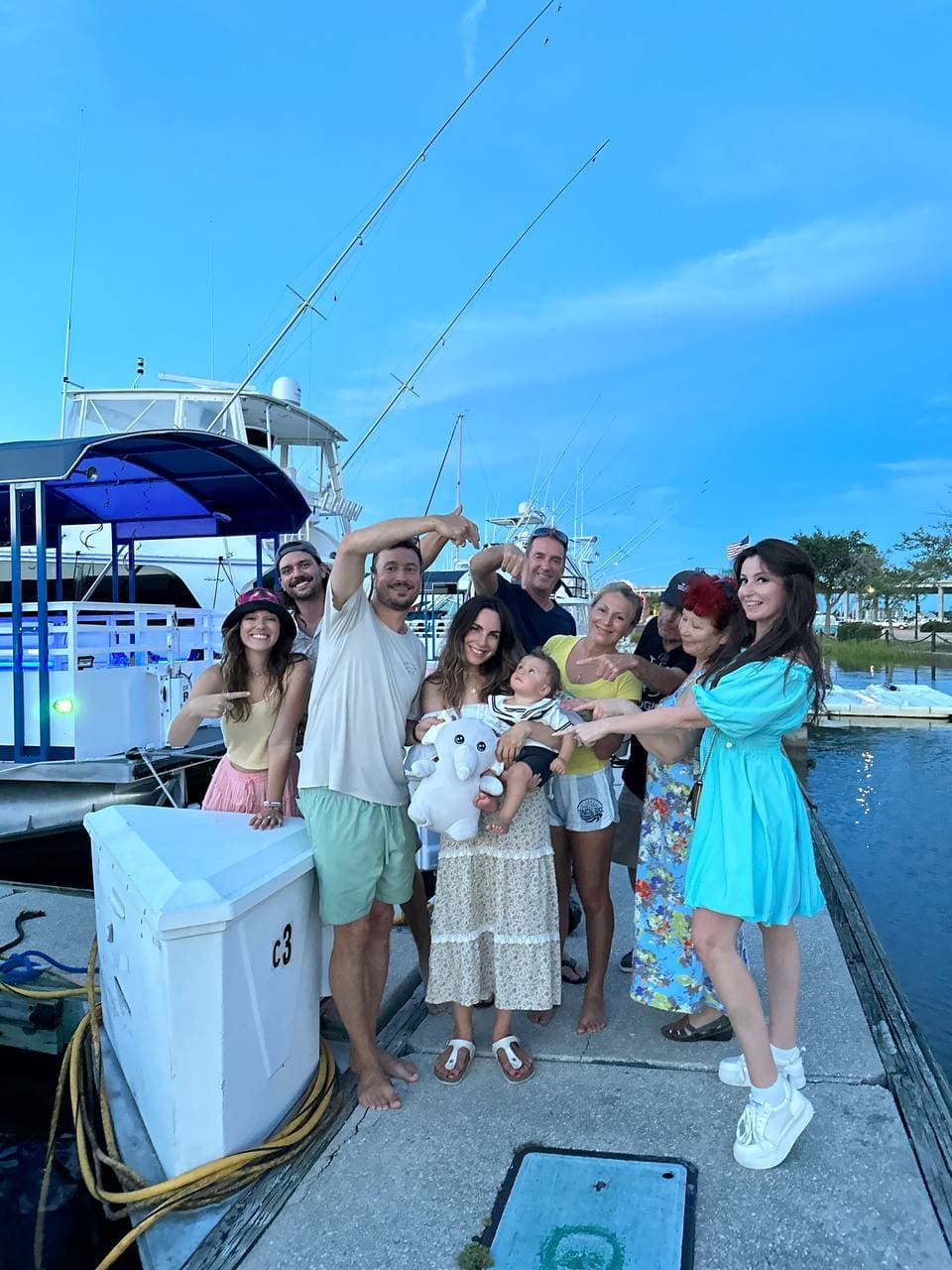 Big happy family taking a picture after a birthday party cruise for their 1 year old kid